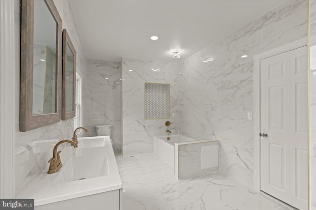 full bathroom featuring marble finish floor, a garden tub, double vanity, and stone wall