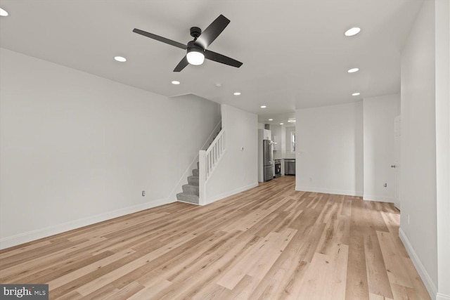 unfurnished living room with baseboards, a ceiling fan, light wood-style flooring, stairway, and recessed lighting