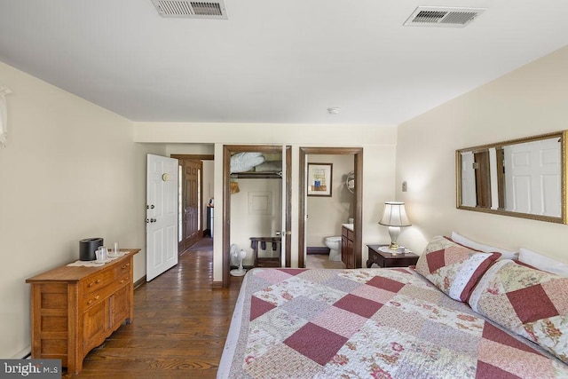 bedroom with dark wood-style flooring, ensuite bath, and visible vents