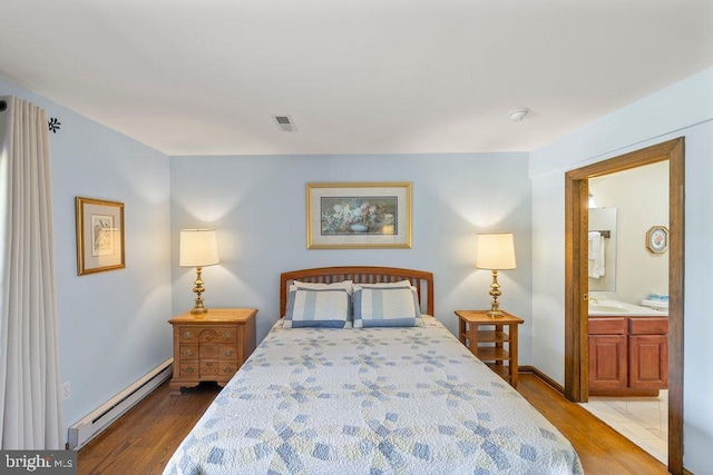 bedroom with baseboards, visible vents, wood finished floors, baseboard heating, and a sink