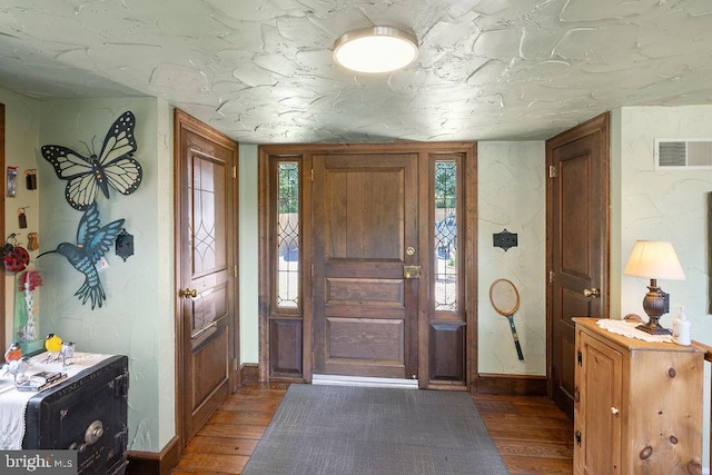 foyer featuring wood finished floors, visible vents, and baseboards