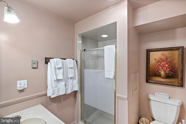 bathroom with vanity, a shower stall, and toilet