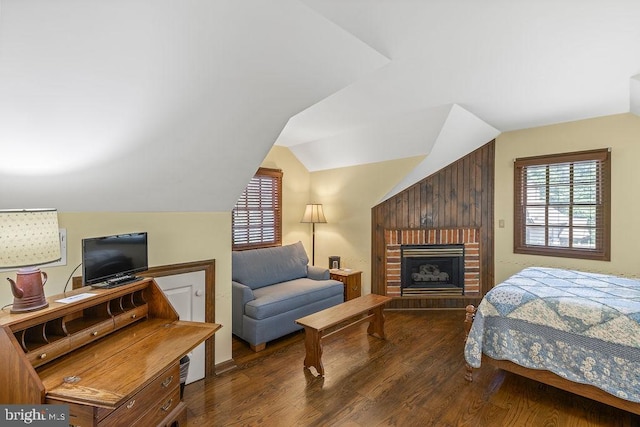 bedroom featuring lofted ceiling, multiple windows, and wood finished floors