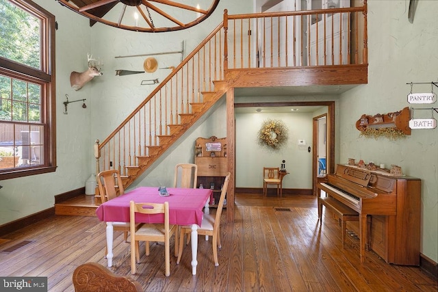 dining room with stairs, visible vents, baseboards, and hardwood / wood-style flooring