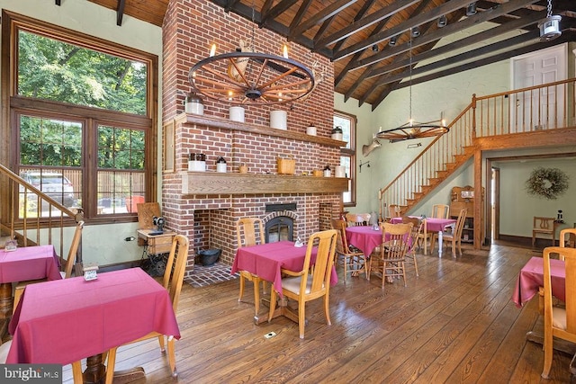 dining area with stairway, a brick fireplace, wood ceiling, beamed ceiling, and hardwood / wood-style floors