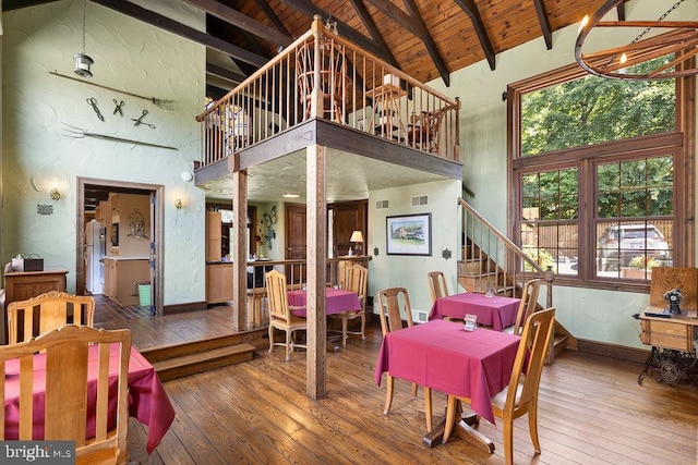 dining space with hardwood / wood-style flooring, wood ceiling, plenty of natural light, and beamed ceiling