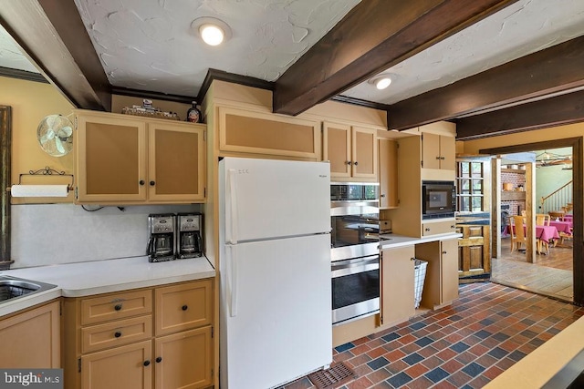 kitchen with freestanding refrigerator, black microwave, light countertops, and stainless steel double oven