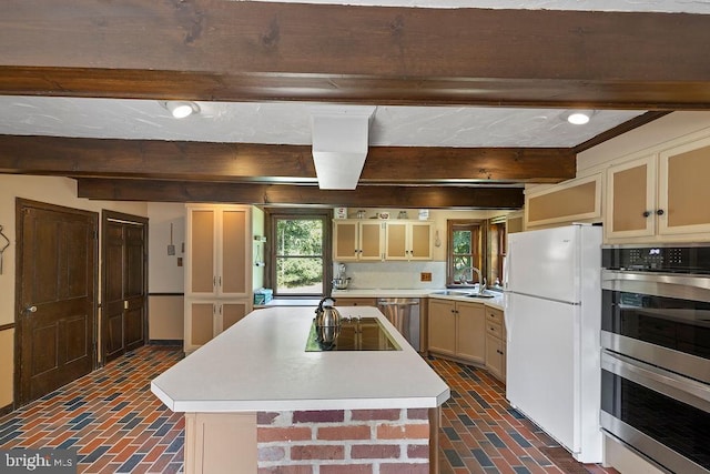 kitchen featuring stainless steel appliances, light countertops, beam ceiling, and brick floor