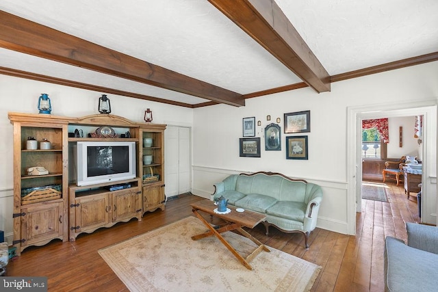 living room featuring beamed ceiling and wood-type flooring