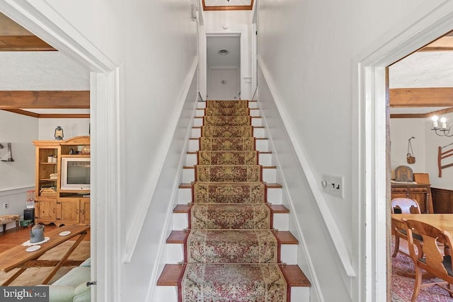 staircase featuring beam ceiling