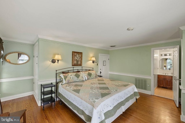 bedroom featuring wood finished floors, visible vents, and crown molding