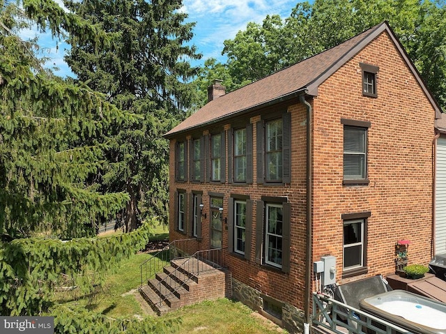 exterior space with brick siding and a chimney