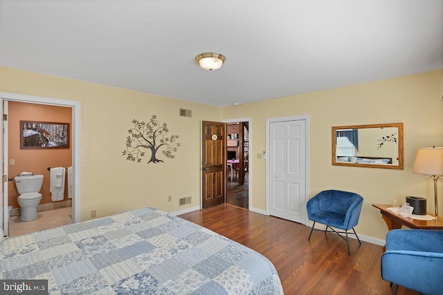 bedroom featuring baseboards, visible vents, and wood finished floors