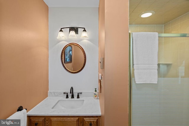 full bathroom with a tile shower and vanity