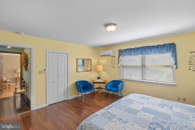 bedroom featuring a wall mounted AC, wood finished floors, and baseboards