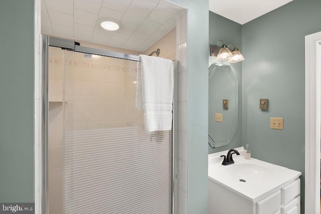 bathroom with a tile shower and vanity