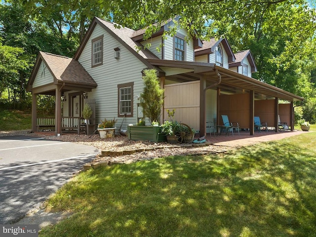 view of side of property with a shingled roof and a yard