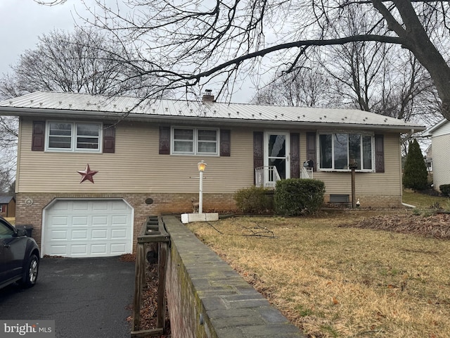 view of front of house with aphalt driveway, brick siding, a front yard, metal roof, and a garage