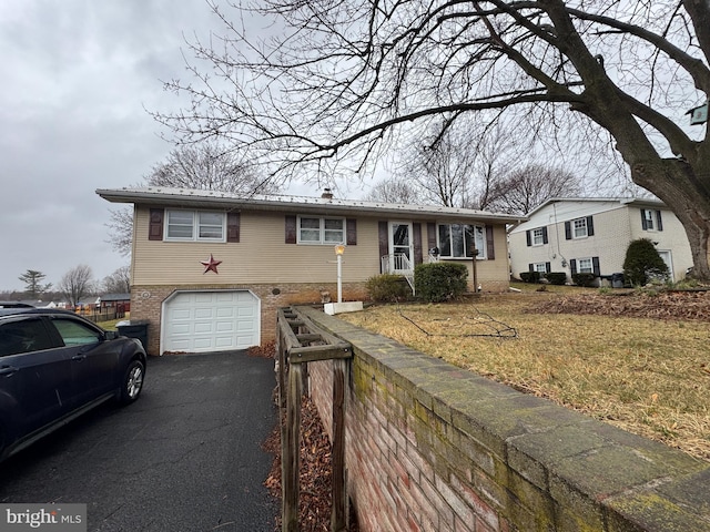 view of front of home featuring brick siding, driveway, an attached garage, and fence