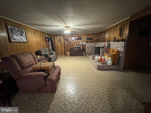 living area with wood walls and ceiling fan