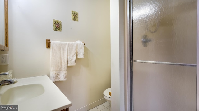 bathroom featuring toilet, vanity, baseboards, tile patterned floors, and a stall shower