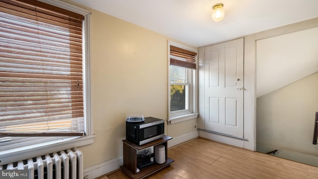 entrance foyer featuring baseboards, light wood-style flooring, and radiator