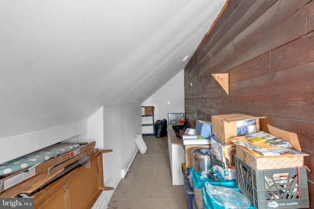 additional living space with wood walls, vaulted ceiling, and concrete flooring