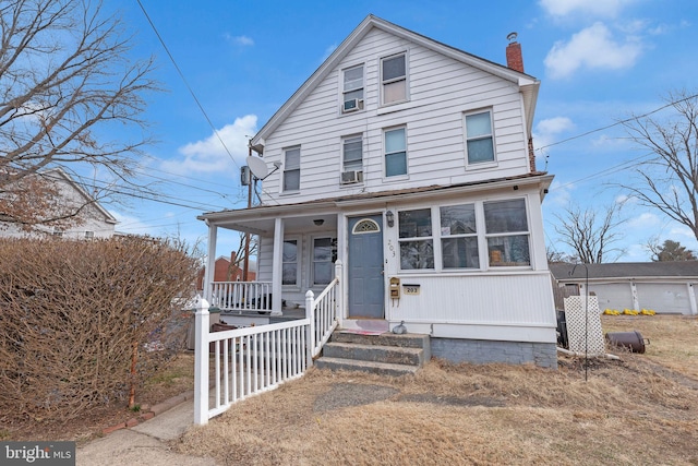 view of front of home with covered porch and a chimney