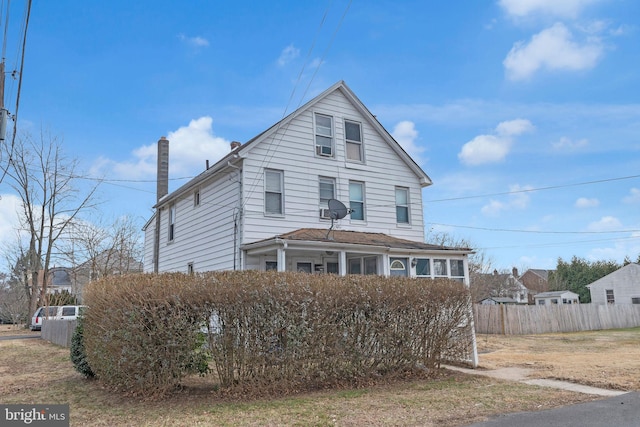 view of front of house with fence and a chimney