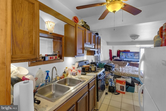 kitchen featuring white appliances, brown cabinetry, a sink, and under cabinet range hood