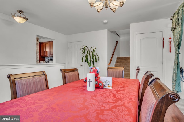 dining room featuring stairway and a notable chandelier