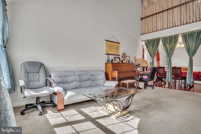 carpeted living area with a towering ceiling