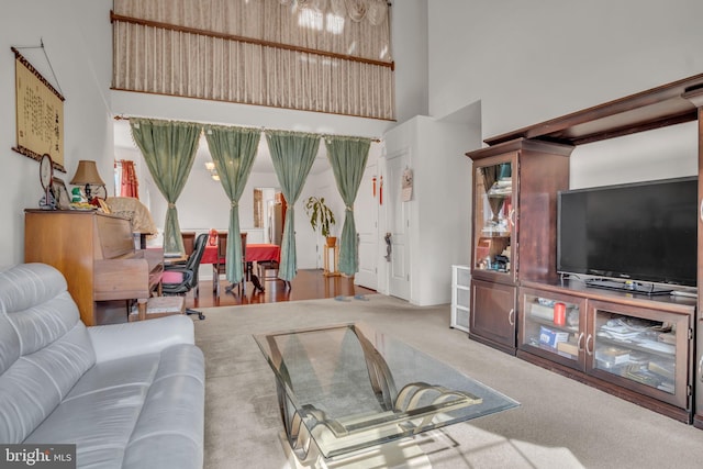 carpeted living room with a towering ceiling