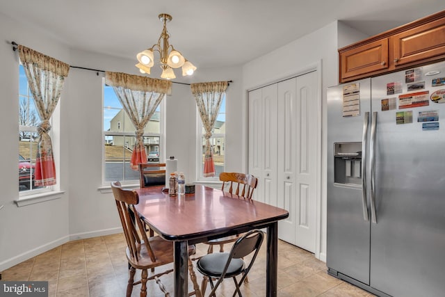 dining area with light tile patterned floors, baseboards, and a chandelier