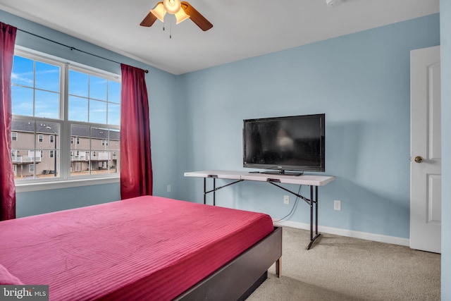 carpeted bedroom featuring ceiling fan and baseboards