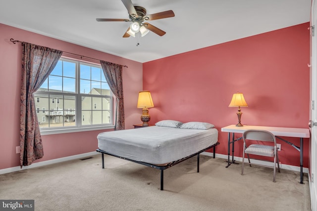 carpeted bedroom featuring a ceiling fan, visible vents, and baseboards