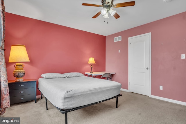 bedroom with baseboards, a ceiling fan, visible vents, and light colored carpet