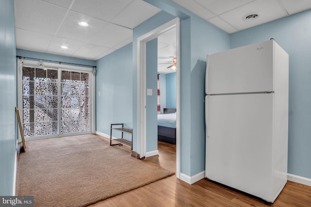 interior space with baseboards, visible vents, a drop ceiling, and wood finished floors