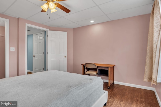 bedroom featuring a paneled ceiling, a ceiling fan, baseboards, and dark wood-type flooring