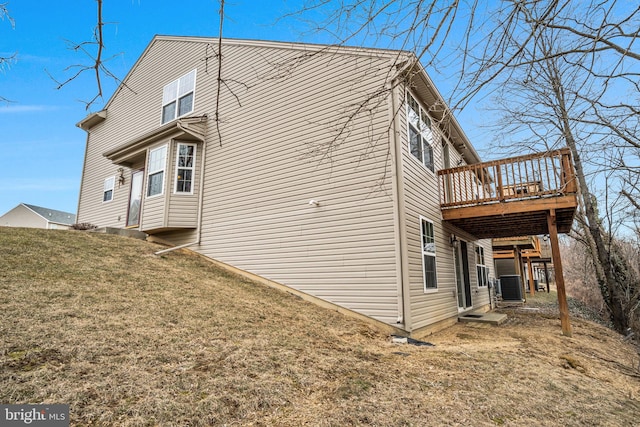 view of home's exterior featuring central AC, a yard, and a deck