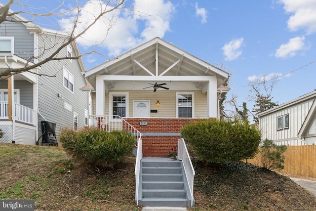 view of front of property with a porch, brick siding, fence, and a ceiling fan