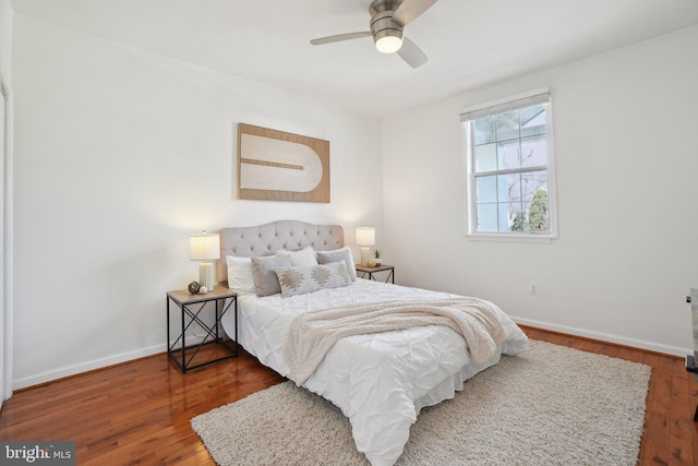 bedroom with ceiling fan, wood-type flooring, and baseboards