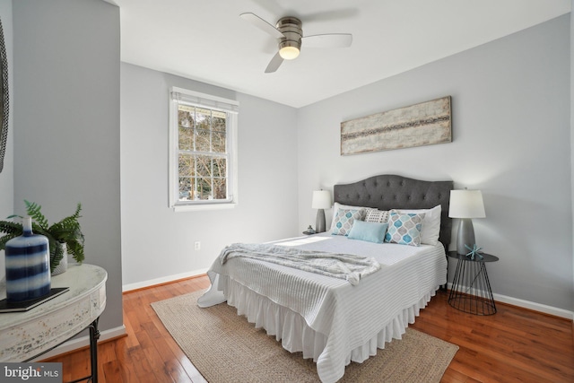 bedroom featuring wood-type flooring, a ceiling fan, and baseboards