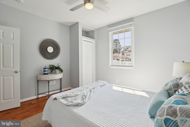 bedroom with ceiling fan, a closet, baseboards, and wood finished floors