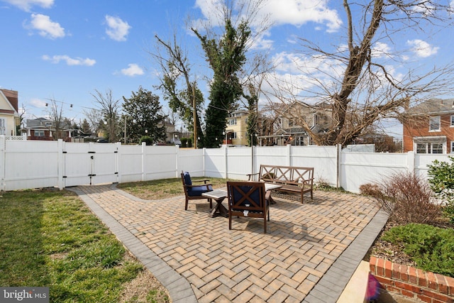 view of patio with an outdoor living space, a fenced backyard, and a gate