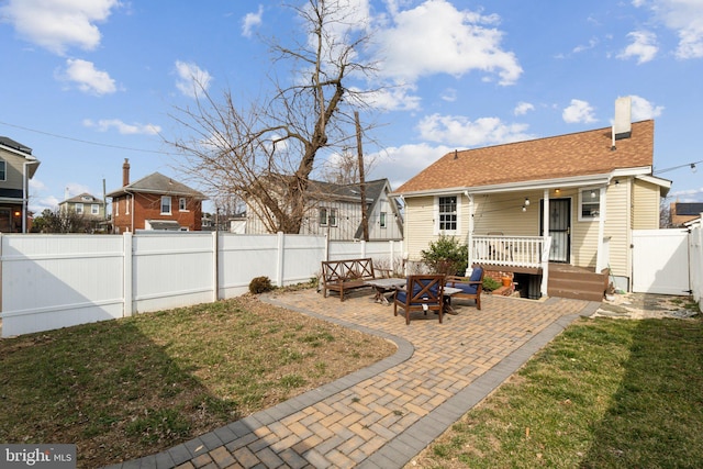 exterior space with a patio, a chimney, a lawn, a gate, and a fenced backyard