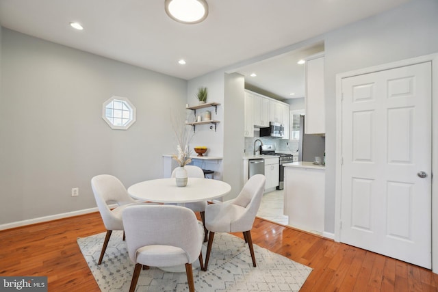 dining space featuring light wood finished floors, recessed lighting, and baseboards