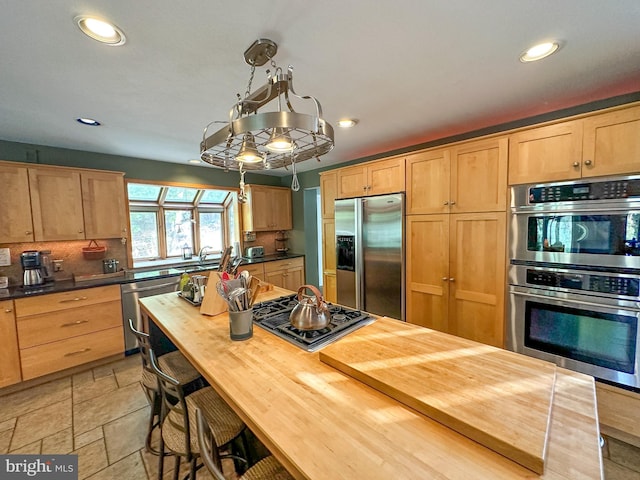 kitchen featuring butcher block counters, appliances with stainless steel finishes, decorative backsplash, and recessed lighting