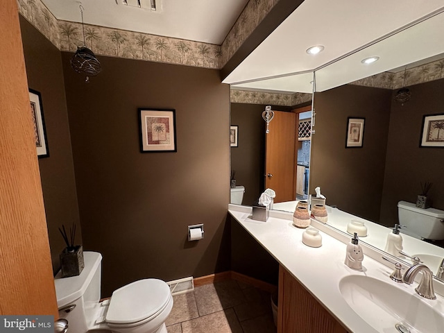 bathroom with toilet, tile patterned floors, baseboards, and vanity