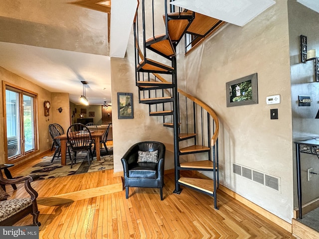 stairs featuring wood-type flooring and visible vents